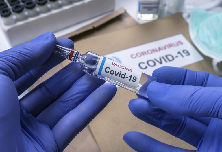 Scientist holds coronavirus vaccine in hospital, conceptual image